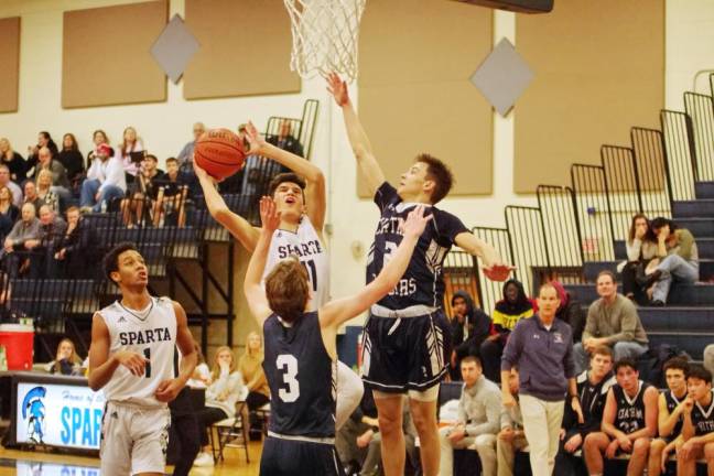 Sparta's Matt Silvey takes the ball towards the hoop against two Chatham defenders in the first half. Silvey scored 4 points.