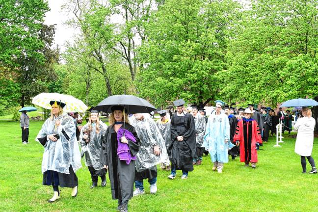 A touch of adversity Faculty members walk into the ceremony, which was delayed by rain.