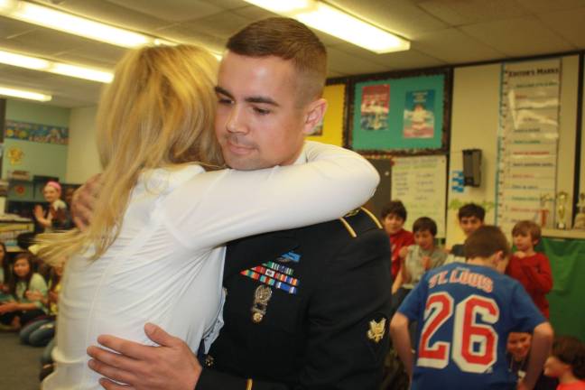 Local soldier visits pen pals Helen Morgan teacher Susan LaBell gives her former student Logan Lynch a warm welcome back.