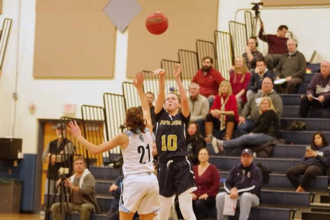 Pope John's Sydney VanDerMark (10) launches the ball during a shot while covered by Sparta's Mason Munier in the third quarter. VanDerMark scored 2 points and grabbed 4 rebounds.