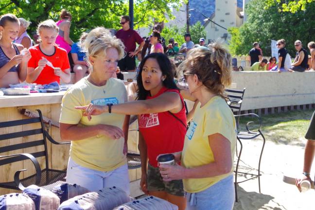 Another big triathlon for Pass it Along Triathlon organizer Eleanor Young (pointing) speaks with volunteers.