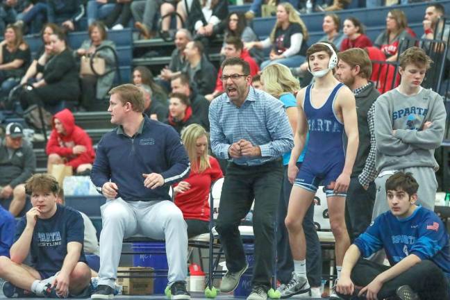 Head coach Frank Battalia jumps to his feet in the heat of the moment as assistant coach John Procoppio keeps watch on a simultaneous Spartan match.
