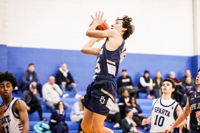 Pope John freshman Ty Plotts attempts a jump shot in the game against Sparta on Thursday, Feb. 1. The Spartans won, 53-31. (Photos by Jay Vogel)