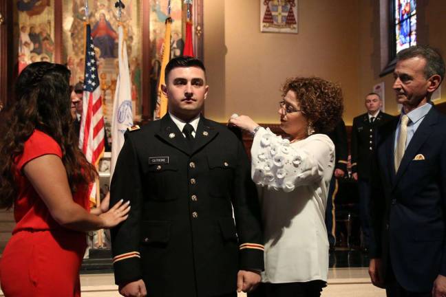 Byram native realizes dream of becoming Army officer Mary Cutrone pins officer “board” on the uniform of her son Frank, while Nick Cutrone and Alessia Nestico look on