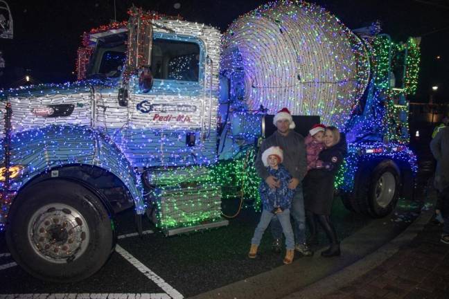 Chris and Ursula Garrett with their children Adrian, 7, and Neil, 4, pose by a truck decorated for the holiday.