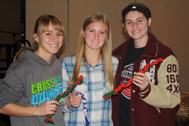 Pass it along holds Family Volunteer Day Rose Ippolito, Hannah Ervey, and Olivia Weiss of Newton High School display their handcrafted dog collars.