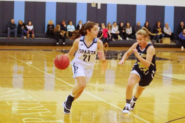 Sparta's Mason Munier dribbles the ball while Pope John's Chloe Captoni tries to keep pace in the first quarter. Munier scored 5 points.