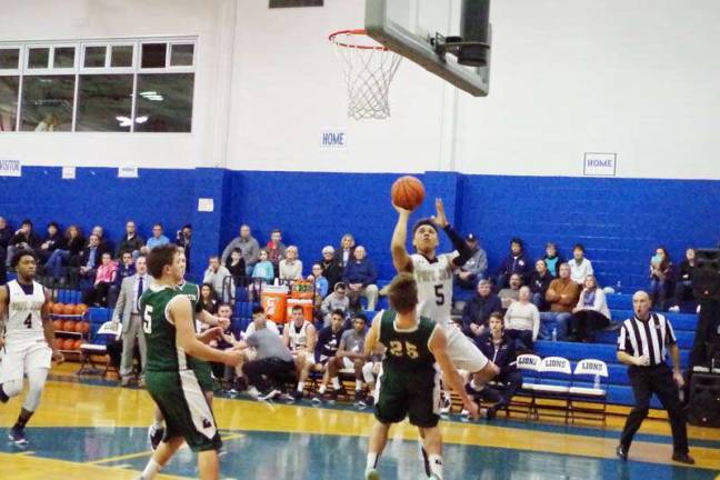 Pope John's Aaron Clarke (5) in the midst of a shot. Clarke scored twenty seven points and grabbed four rebounds.