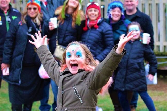 Lake Mohawk German Christmas Market 2018 A young girl photobombs the group of Lake Mohawk Christmas Market attendees posing behind her on the crowded, festive Boardwalk.  "I've been doing this all day," she laughed. (Photo provided).