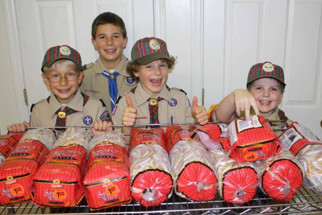 Scouts dish out in soup kitchen Jonathan, Thomas and Erik and Den Chief Erich help make peanut butter and jelly sandwiches.