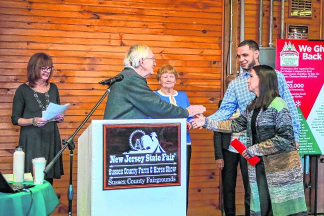 Benjamin and Heather Davey thank Dan Sarnowski for the grant to Benny’s Bodega in Newton. (Photo by Brielle Kehl)