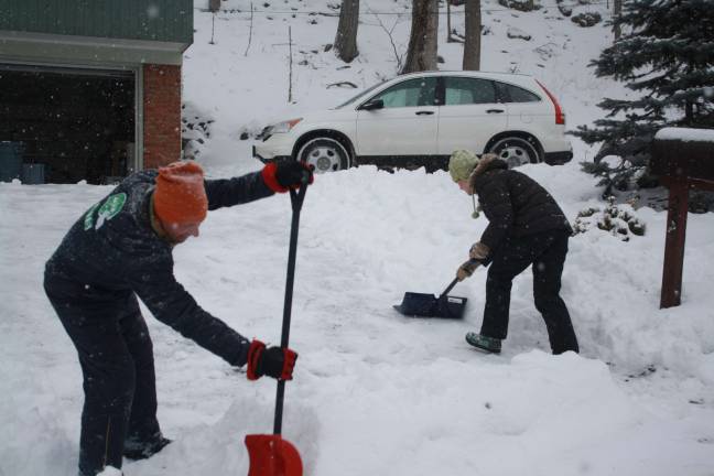 Andrew and Heather Lazar get some pre-shoveling done on Monday.