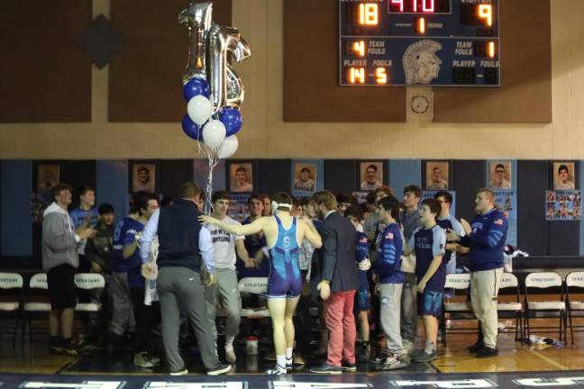 Senior Garrett Stewart is surrounded by his team after he completed his record making match.