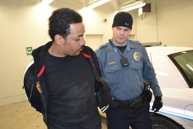 Busted! Photo Courtesy of the Sparta Township Police Department Officer Adam Carbery escorts Leevan Lawrence into the Sparta Police Department's cellblock.