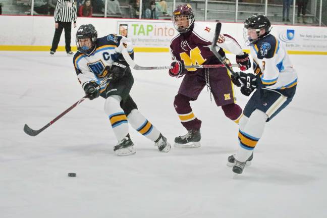 Madison bests Sparta-Jefferson on the ice In pursuit of the puck.