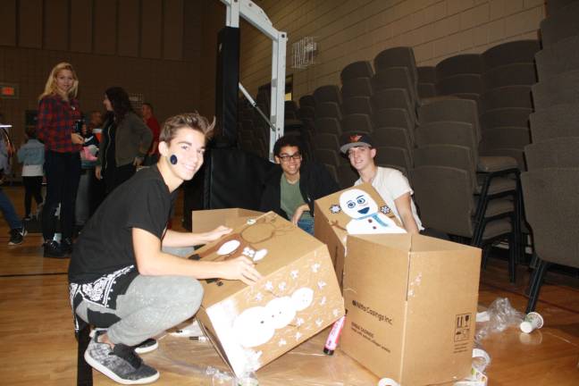 Pass it along holds Family Volunteer Day Tyler Mc Ginnis, Mark Young and Cole Baldini decorate boxes with holiday images.