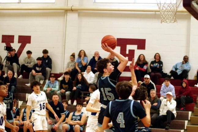 SB3 Sparta's Tyler Conlee (15) raises the ball toward the hoop during a shot. He scored 16 points in the game against Warren Hills.