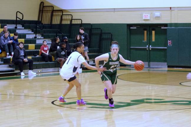 Sussex Tech's Teagan Smith handles the ball while covered by Koinonia defender Milani Feliz. Smith scored six points.