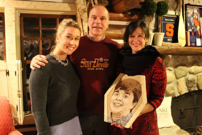 Isak's family, from left, sister Ellen Anderson, father Tom Anderson and mother Kylen Anderson, with the floragraph made in Isak's memory.