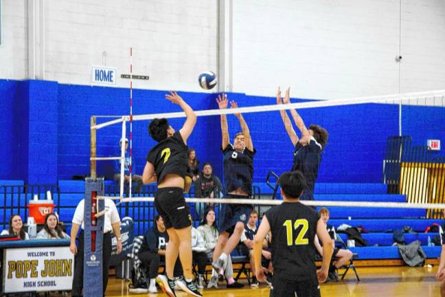 Bergen Charter and Pope John players battle above the net.