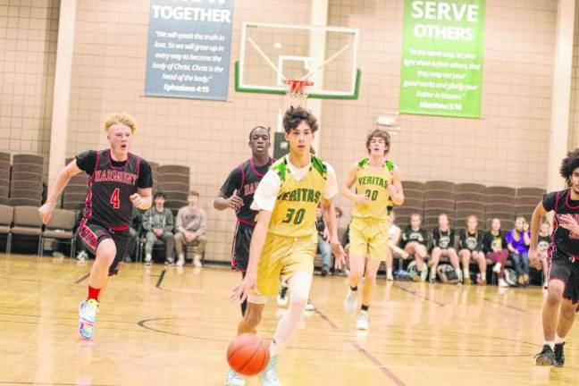 Veritas guard Dallas Tanis dribbles the ball. He scored nine points and grabbed seven rebounds. (Photo by George Leroy Hunter)