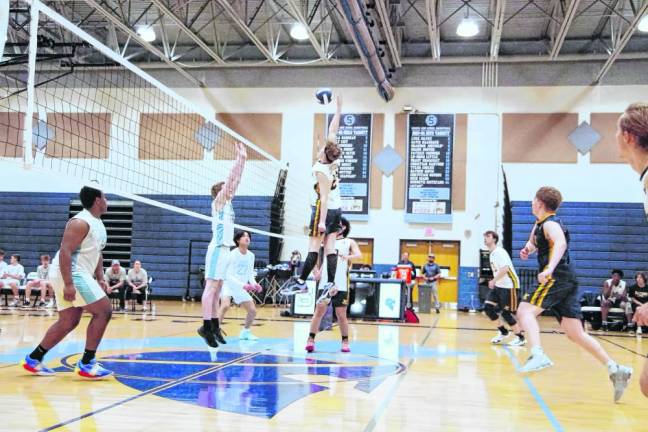Jefferson's Raymond Bradley reaches for the ball high above the net. He was credited with two kills and two digs.