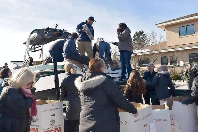 Staff members of Off Shore Marine in Branchville unload donated toys for Project Self-Sufficiency in Newton.