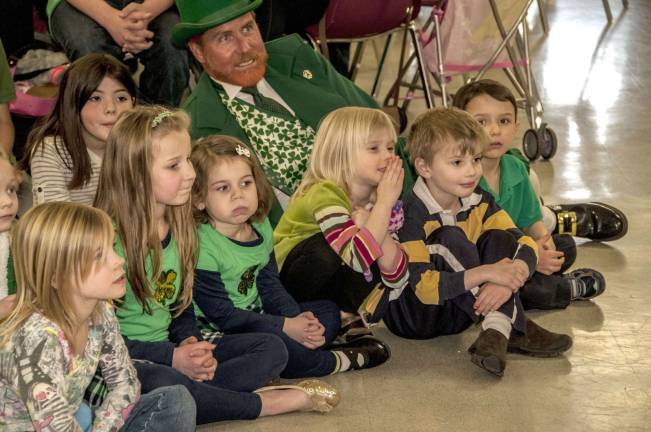 Liam the Leprechaun sits with some youngsters and watches the Peter Smith School of Irish Dancers perform.