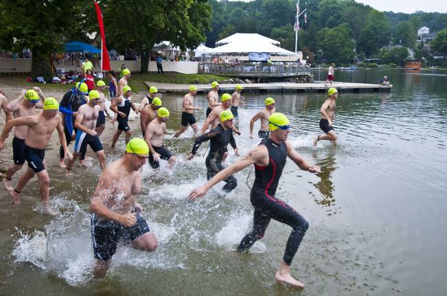 Triathlon draws athletes from 13 states the first wave enters the lake.