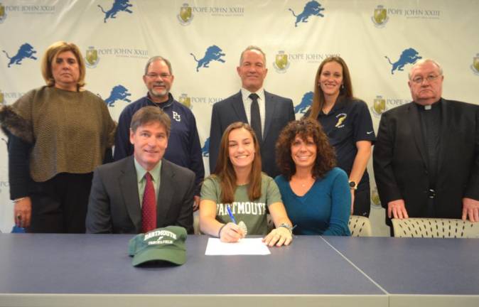 Bridget McNally, announces her commitment to track and field at Dartmouth College. Seated next to McNally, from left, are her parents, Stephen andTrisha. Back row: Athletic Director Mia Gavan, assistant track and field coach Tom Morro, Principal Gene Emering, assistant track and field coach Ashley DiGidio, and Pope John President Rev. Msgr. Kieran McHugh.