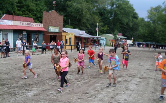Wild West City celebrates anniversary Children compete in the horse stick race.