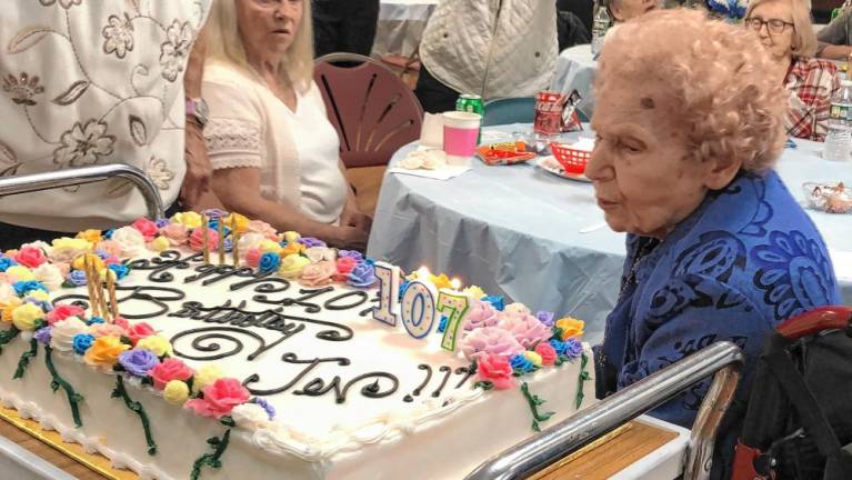 Newton woman turns 107 Jennie Switzer, 107, of Newton blows out the candles on her birthday cake Saturday, May 18. The cake, with 107 roses, was made by Chad Gasiorek of the Sussex County Technical School bakery. (Photos by Kathy Shwiff)
