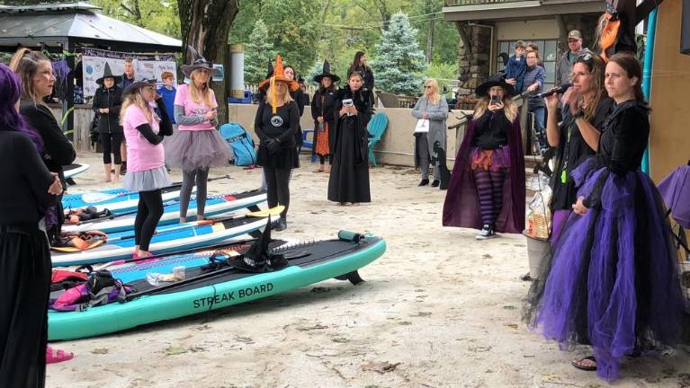 Witches Paddle organizer Dodie Guardia, second from right, gives instructions to participants. At right is her co-host Susan Parnell. (Photo by Kathy Shwiff)