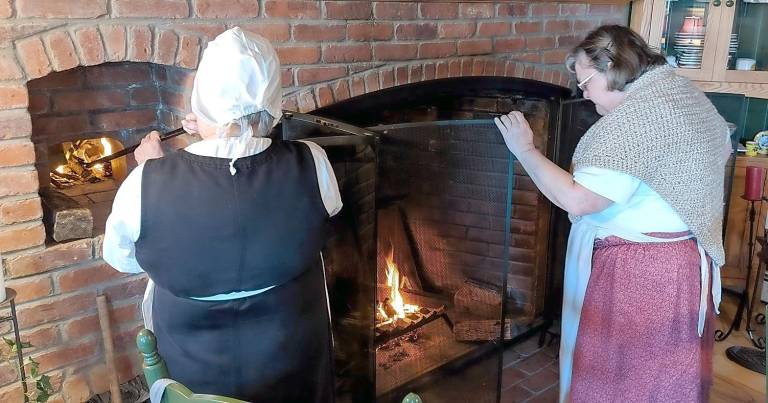 Open hearth cooking Una Lee and Jane tend the fires.