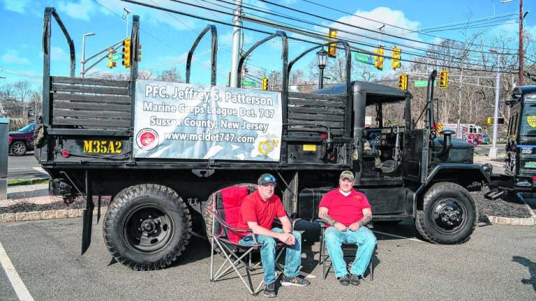 Josh Conklin and Glen Strizver sit in front of a Marine Corps League truck before the parade.