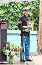 A marine holds a photo during the ceremony.