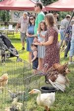 A young family surrounded by some of the animals from the petting zoo at the 2021 Annual History Day program.