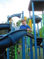 CIP1 Aidan Heninger-Lowell, 7, goes down the slide at the new completely inclusive playground at C.O. Johnson Park in Byram. (Photo by Theresa Esposito)