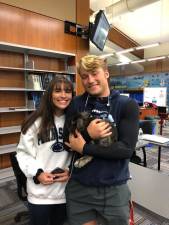 Therapy rabbit in the arms of 12th graders Austin Castorina and Lauren Geoff.