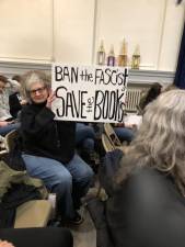 Simonetta Jean of Sparta holds up a sign at the Board of Education meeting Thursday, Feb. 23.