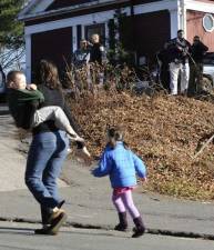 Ghosts of school shootings past: A mother runs with her children as police canvass homes in the area following a shooting at the Sandy Hook Elementary School in Newtown, Conn., on Dec. 14, 2012. 27 people died in that school shooting, including 18 children. AP Photo/Jessica Hill