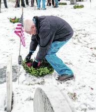Chris Kuever places a wreath.