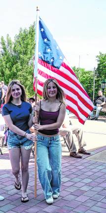 Brenna Koroski and Juliana paoluzzi carry the first official flag of the U.S.