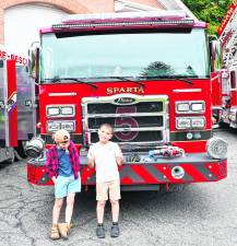 Michael Yanko and Colton Steffen of Sparta pose in front of a fire truck.