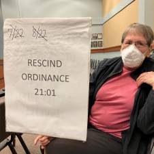 Vivian Perlmutter holds her sign during the township council meeting to demonstrate her opposition to the proposed mega-warehouse development on Demarest Road.