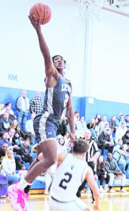 Pope John's Jayden Crocker raises the ball high during a shot. Crocker scored 16 points.