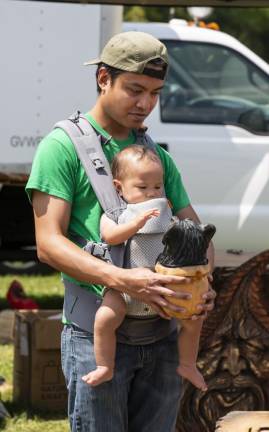 FR29 Jaime Quevedo of Budd Lake and his son Dominico, 11 months, look at a carving of a bear in a honeypot at the display of Freehand Custom Carvings. (Photo by John Hester)