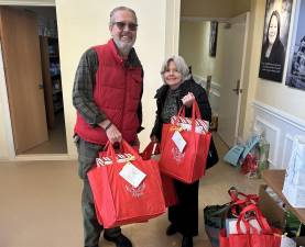 <b>Alice and Kevin Prendergast assemble gift bags for local senior citizens as part of Project Self-Sufficiency’s Earth Angels initiative.</b>