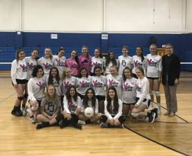 Haley Ward (right), Project Self-Sufficiency, receives a donation for the agency’s breast health education program from the members of the Pope John Women’s Volleyball Team.