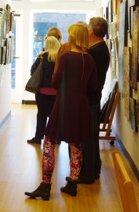 Visitors carefully study the work of Sussex County artist Laura Dudes.